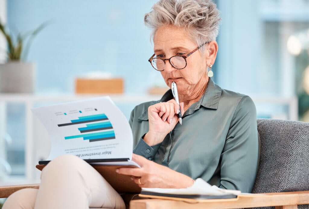 Marketing report, data and business woman planning company budget, economy growth on paper and thinking of investment analytics. Corporate accounting, financial strategy and accountant with research.