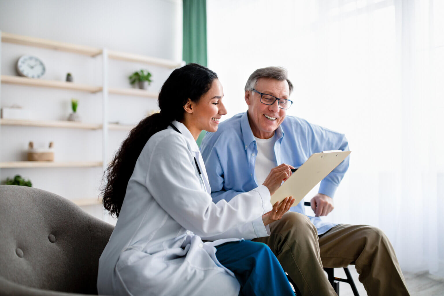 Female presenting doctor reviews information with male presenting patient at the point of care