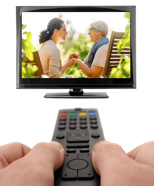 Hands on a remote facing a TV screen. Female presenting patient on TV screen with a female presenting woman.